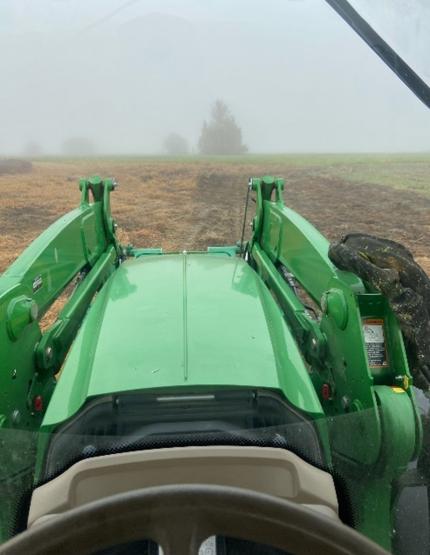 View from interior of tractor while mowing during one foggy morning.
